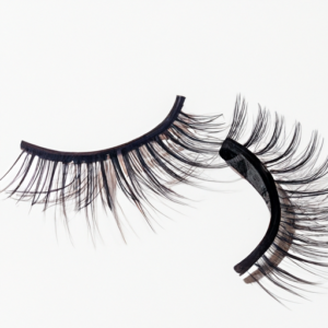 A pair of false eyelashes with one curled upwards in a spiral shape.