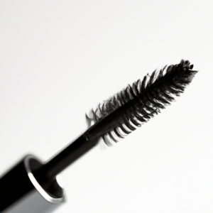 A close-up of a mascara brush on a white background.