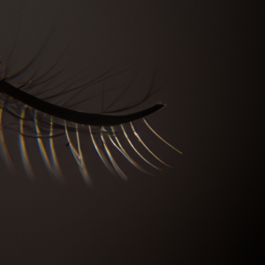 A close-up of a single eyelash, with a black background.