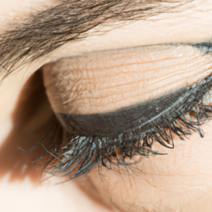 A close-up of an eye with a smudged mascara line along the lashes.