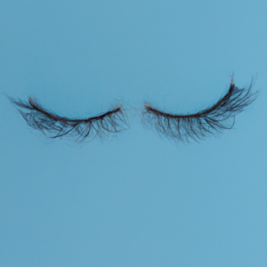 A pair of long eyelashes, with a light blue background.