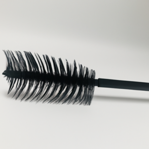 A close-up of an eyelash brush with a clean, white background.