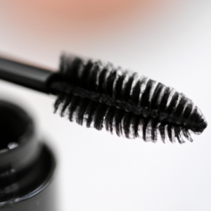 A close-up of a make-up brush with mascara on the bristles.