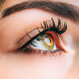 Close-up of a woman's eye with long eyelashes curling upwards.